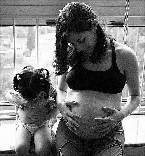 Девочка разглядывает беременную женщину.
